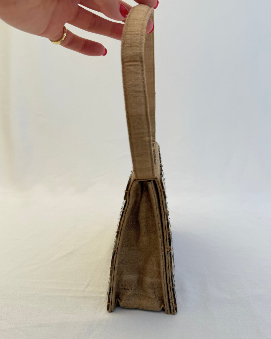 Side handle view of the Bottega Veneta 1997 Rare Vintage Canvas Top Handle Bag neutral mother of pearl detailing
