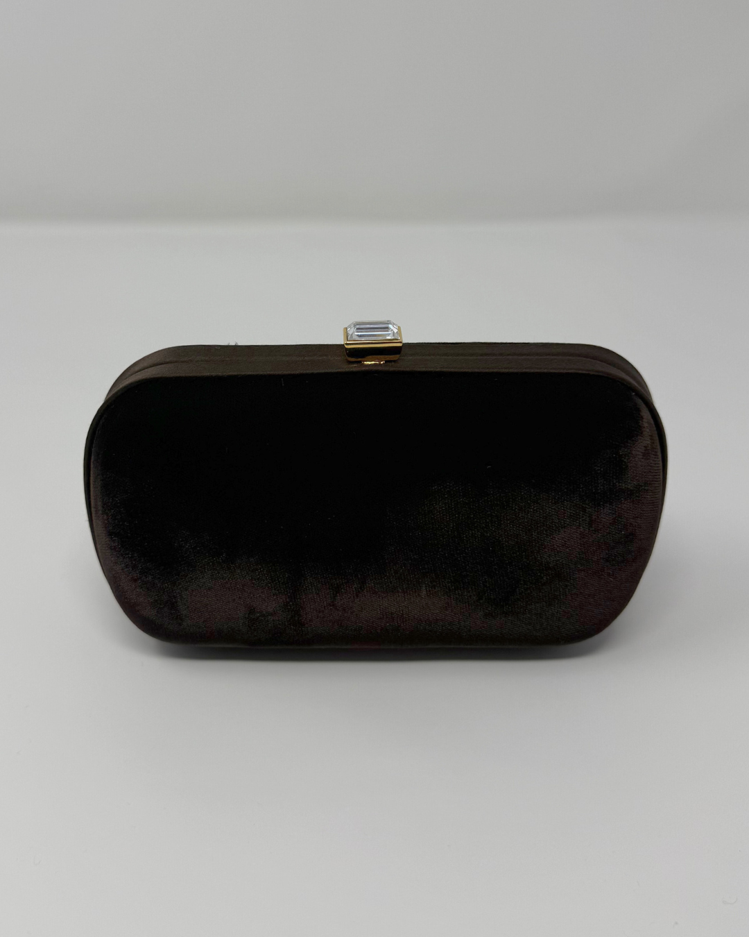 Brown velvet vintage clutch bag with a gold clasp on a white background