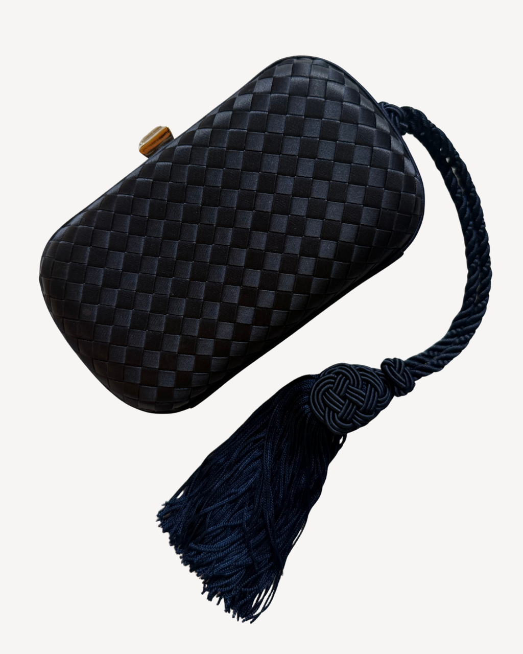 Navy blue woven satin Bottega Veneta vintage intrecciato clutch with a tassel on a white background