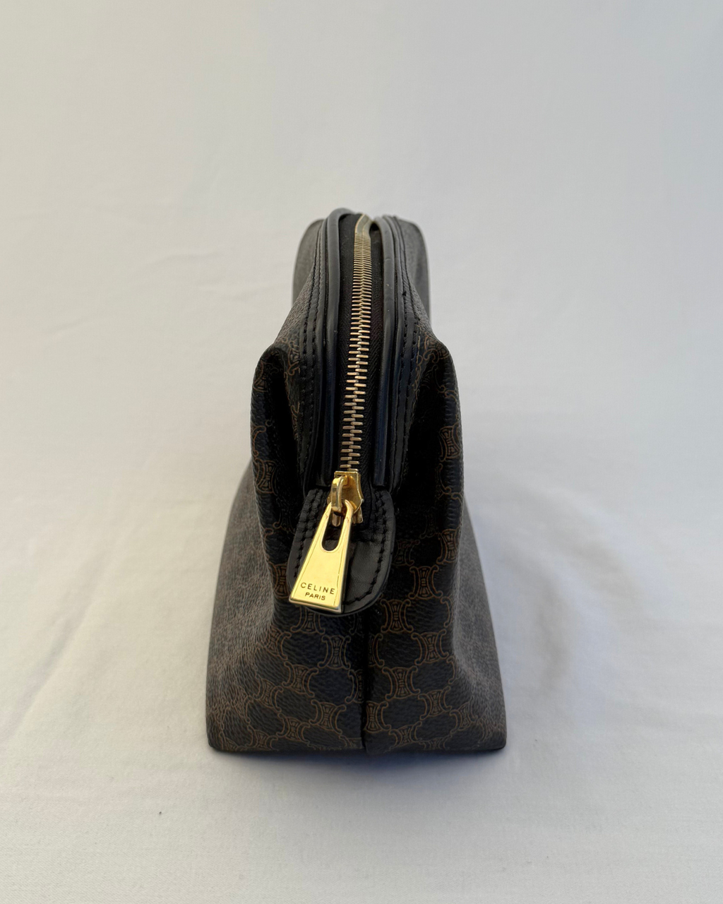Side angle with gold hardware of Celine Vintage Macadam Portfolio Brown Cosmetic Bag on white background