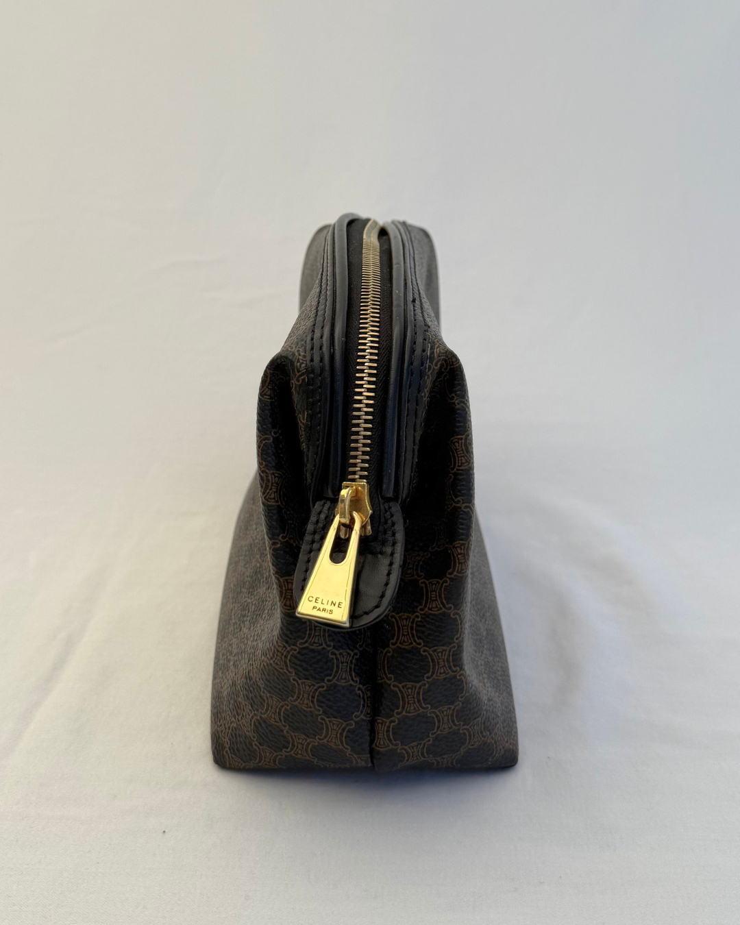Side angle with gold hardware of Celine Vintage Macadam Portfolio Brown Cosmetic Bag on white background
