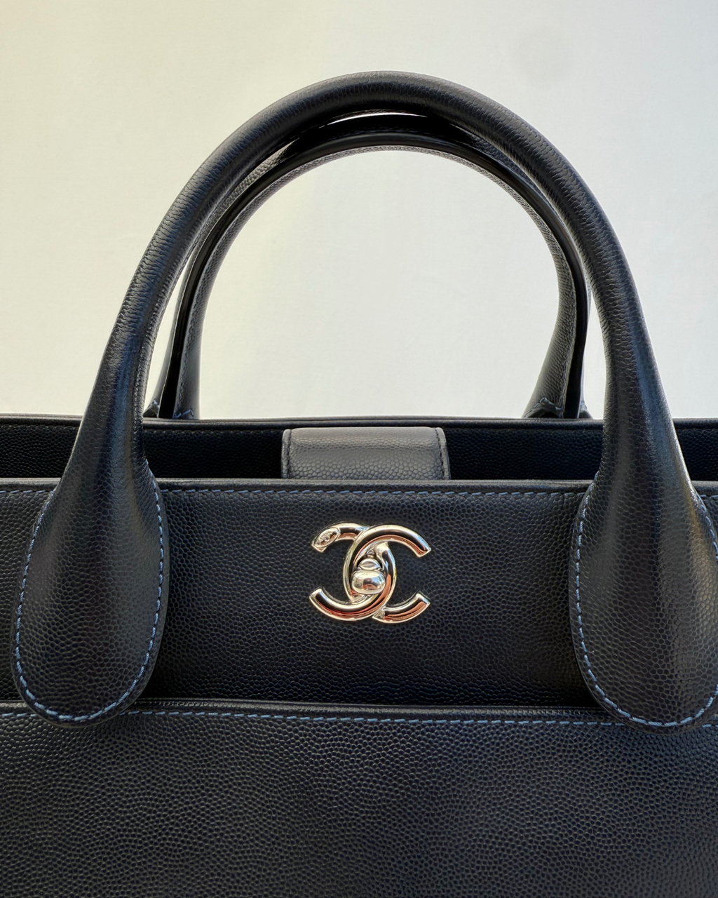 Close up of the Interlocking CC Chanel logo of the Chanel 2015 Medium Executive Cerf Caviar Leather Tote Bag Navy Blue Vintage