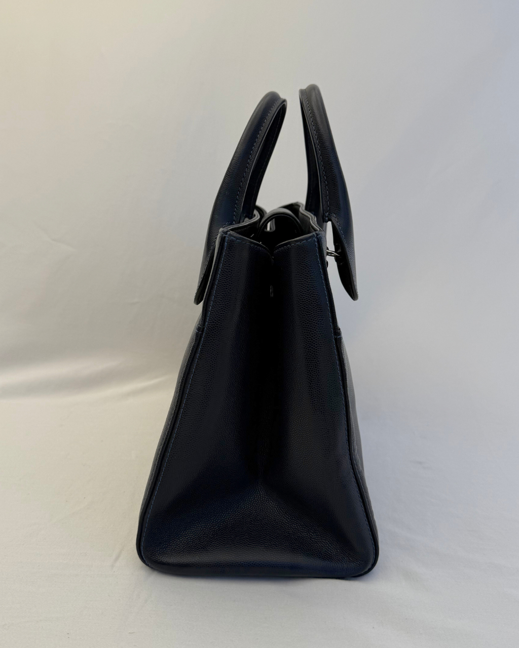 Side angle of the Chanel 2015 Medium Executive Cerf Caviar Leather Tote Bag Navy Blue Vintage