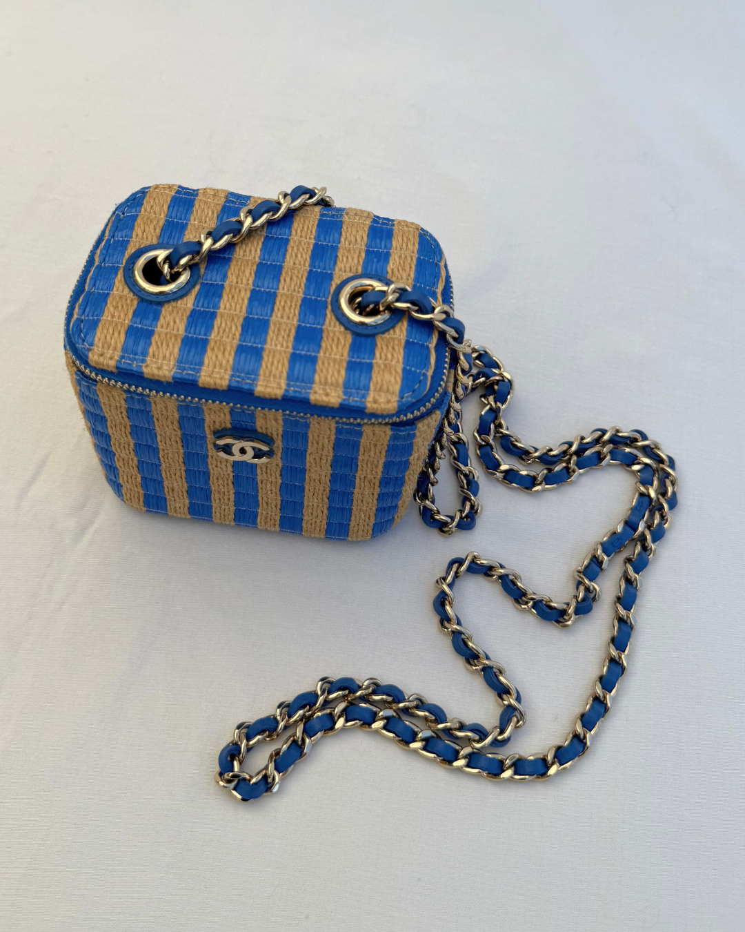 Top detail view of Chanel 2021 Raffia Mini Vanity Case blue and raffia striped leather pre-loved vintage handbag on a white background with old chain strap