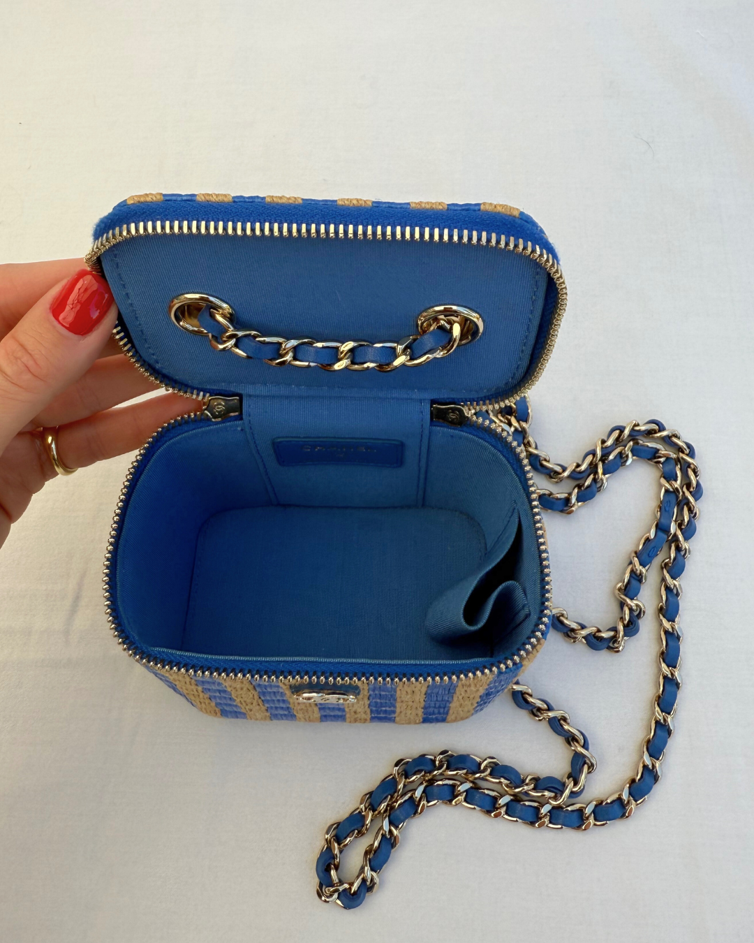 Inside view of Chanel 2021 Raffia Mini Vanity Case blue and raffia striped leather pre-loved vintage handbag on a white background