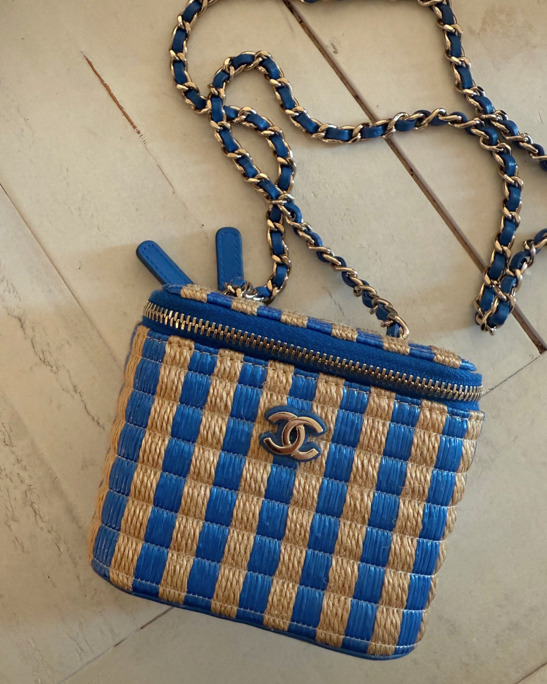 Top angle of the Chanel 2021 Raffia Mini Vanity Case blue and raffia striped leather pre-loved vintage handbag on a wooden table