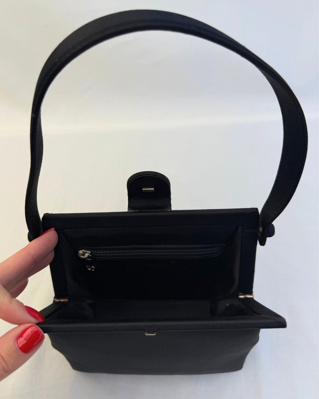 Inside view of CC clasp closure of Chanel Rare Vintage 1997 Mini Satin Frame Evening Bag on white background satin lining