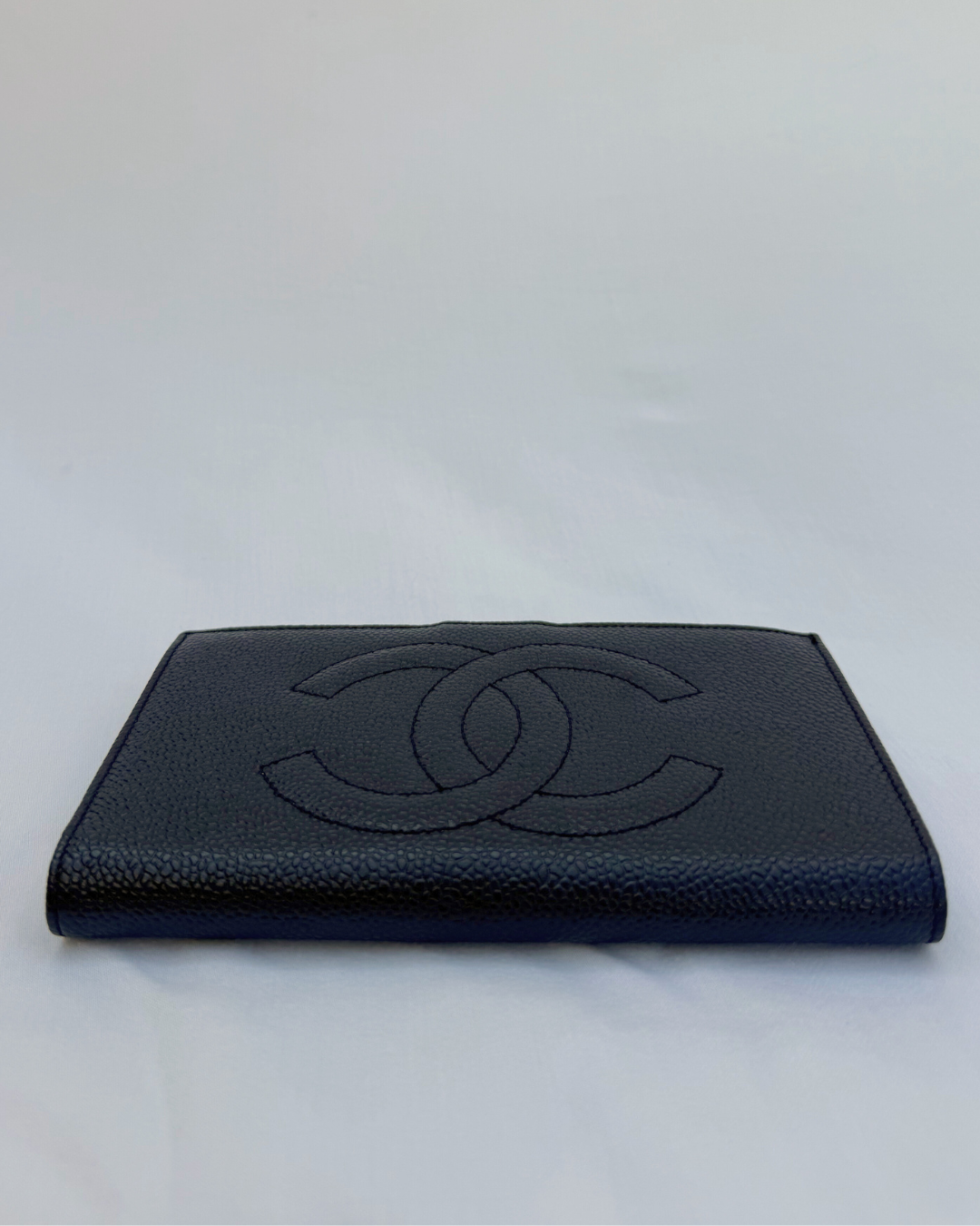 Black caviar leather vintage wallet with Chanel logo on a white background