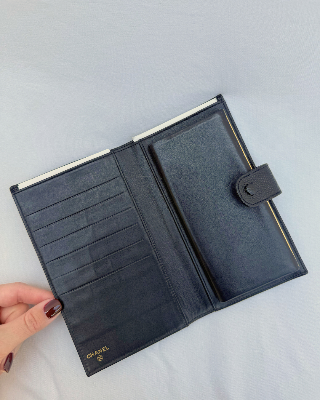 Black caviar leather vintage wallet with Chanel logo on a white background inside view