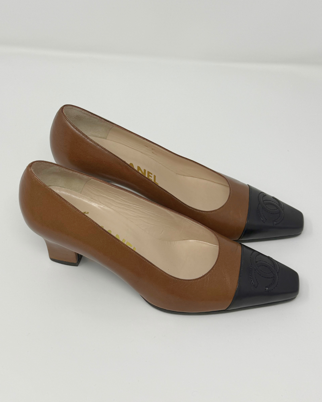 Pair of brown and black high-heeled shoes on a white background