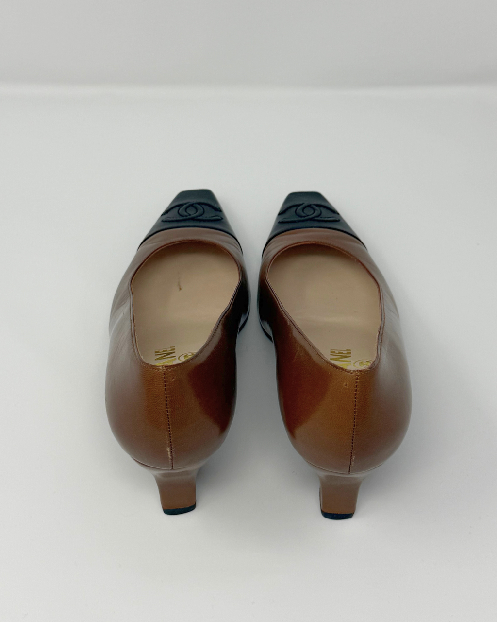 Pair of brown high-heeled shoes on a white background