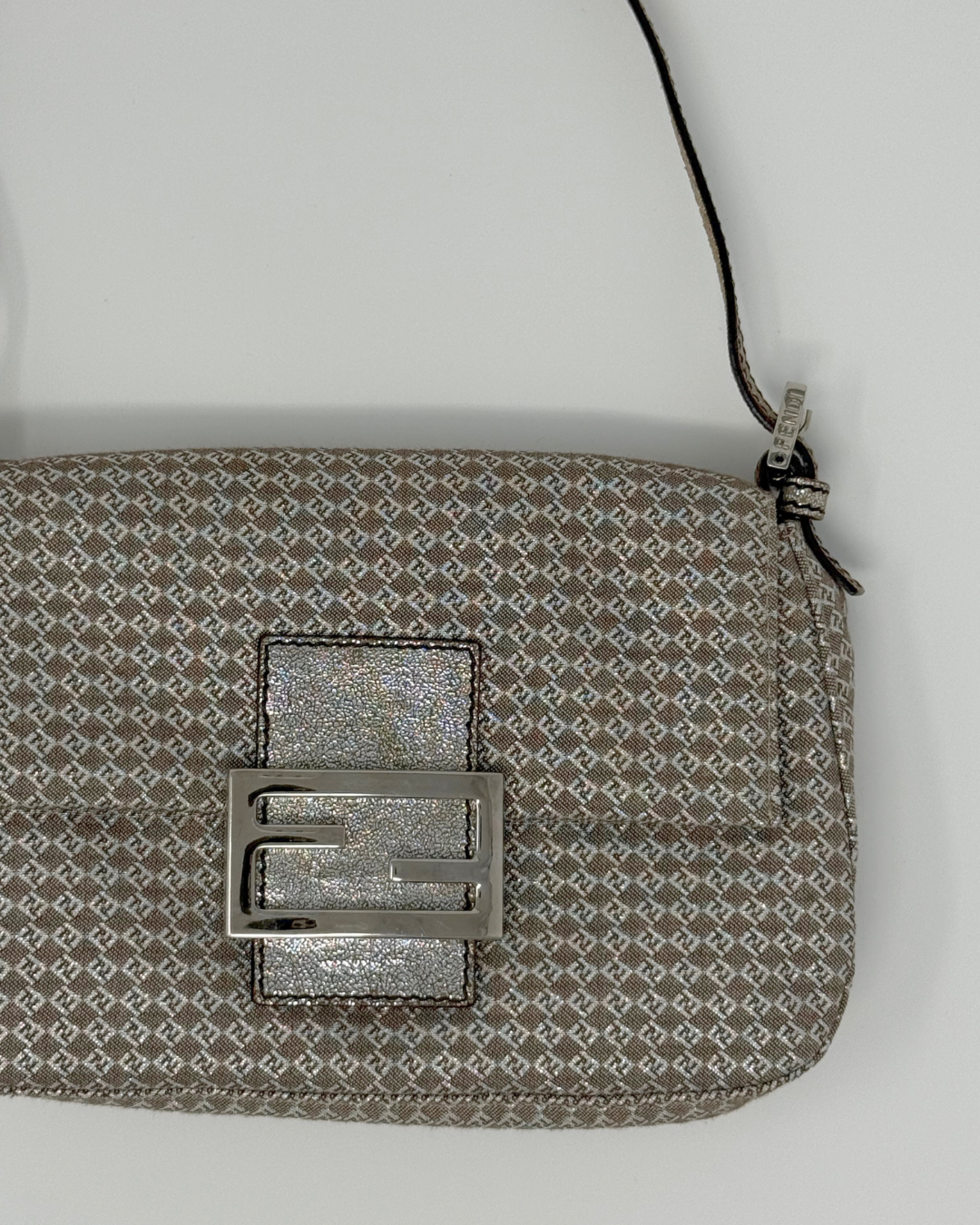 Patterned pouch with a metallic buckle on a light gray background