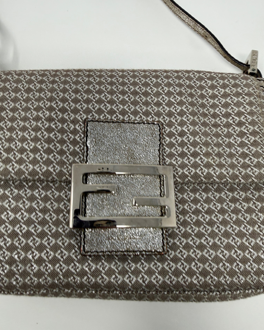 Close-up of a patterned Fendi vintage bag with a metallic buckle on a white background