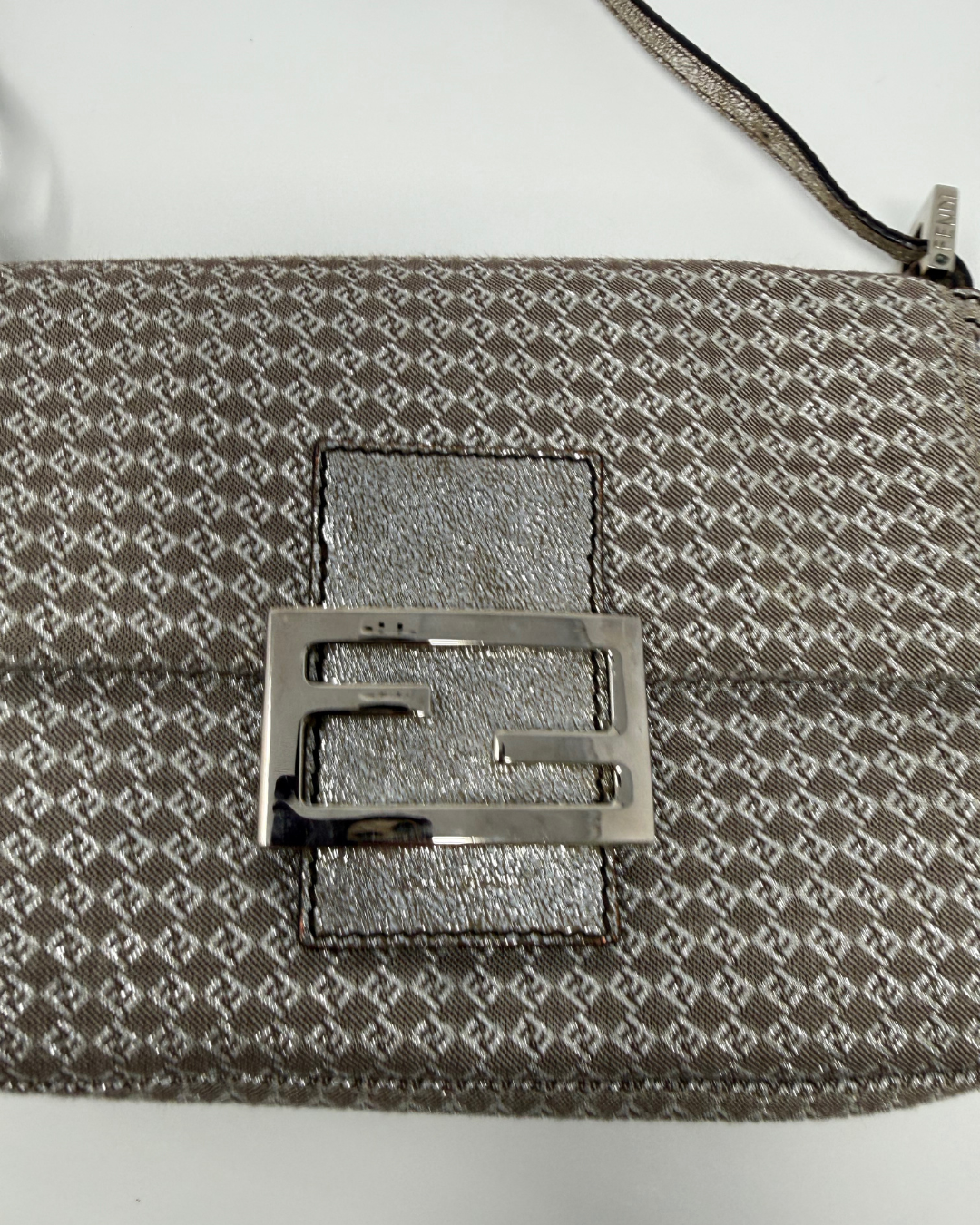 Close-up of a patterned Fendi vintage bag with a metallic buckle on a white background