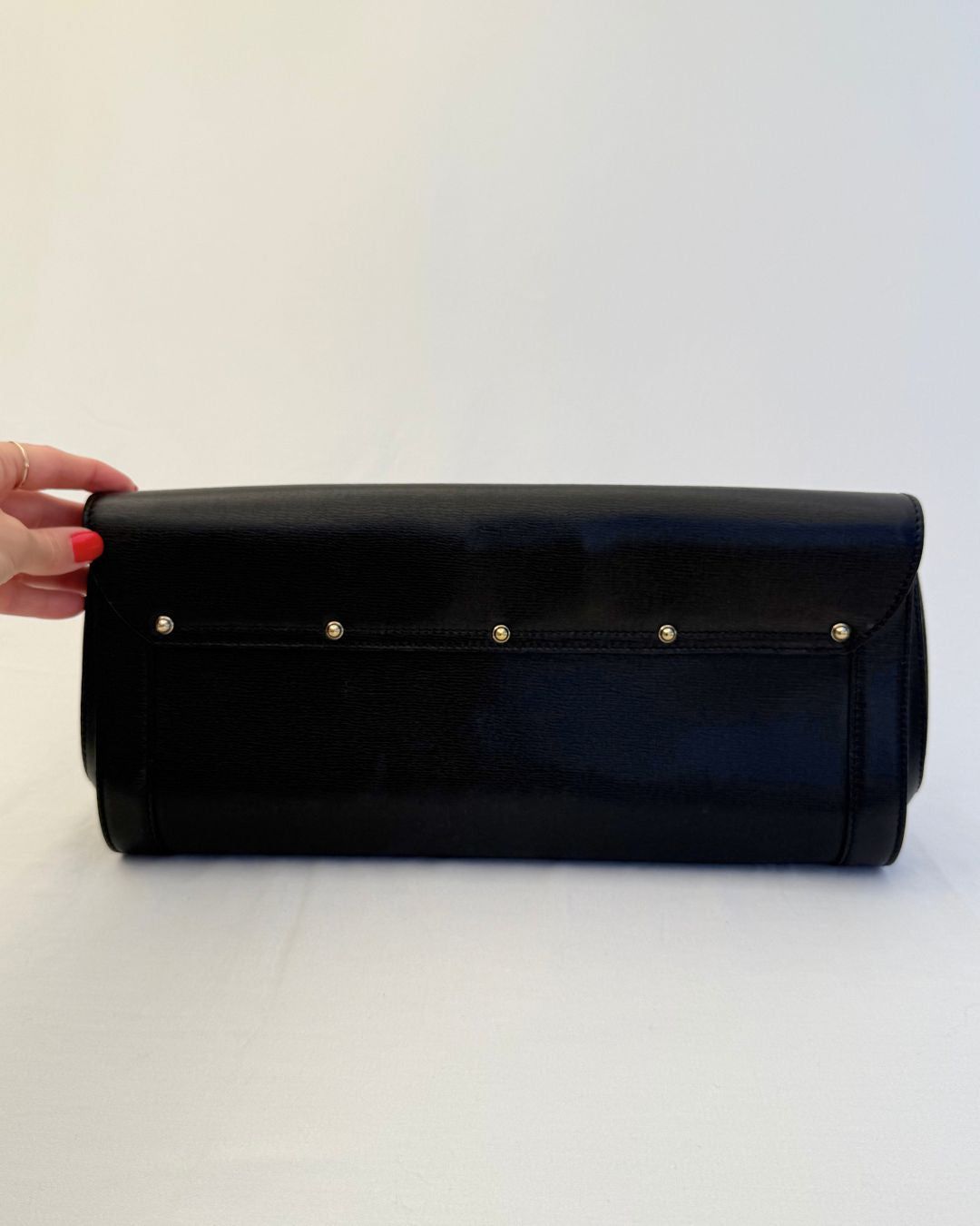 Backside view of Gucci Vintage Black Leather & Bamboo Clutch with gold hardware on white background
