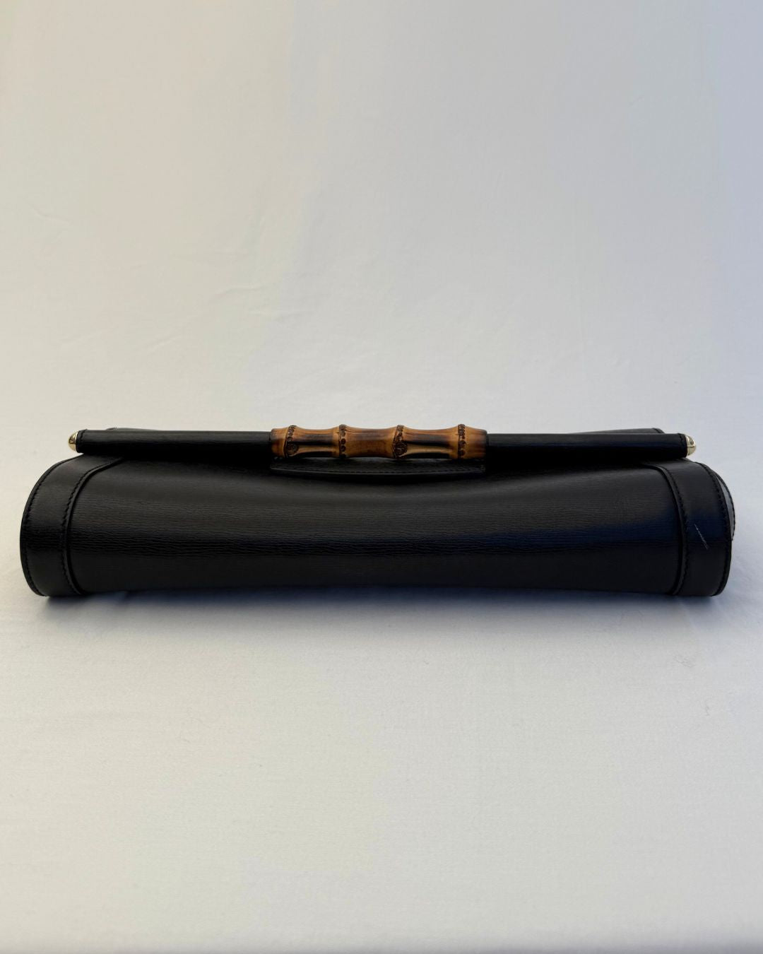 Bottom view of Gucci Vintage Black Leather & Bamboo Clutch on white background