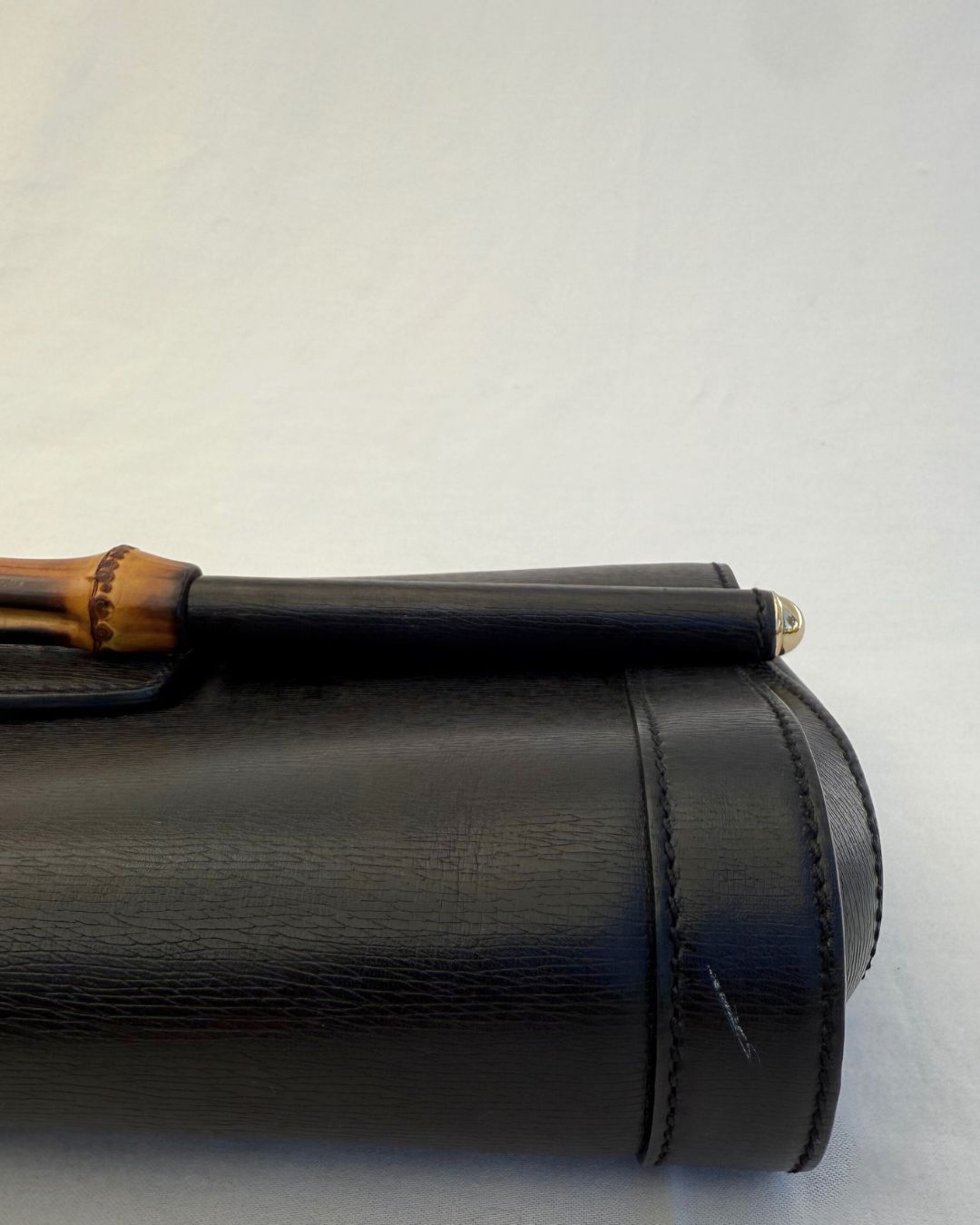 Up close view of Gucci Vintage Black Leather & Bamboo Clutch on white background