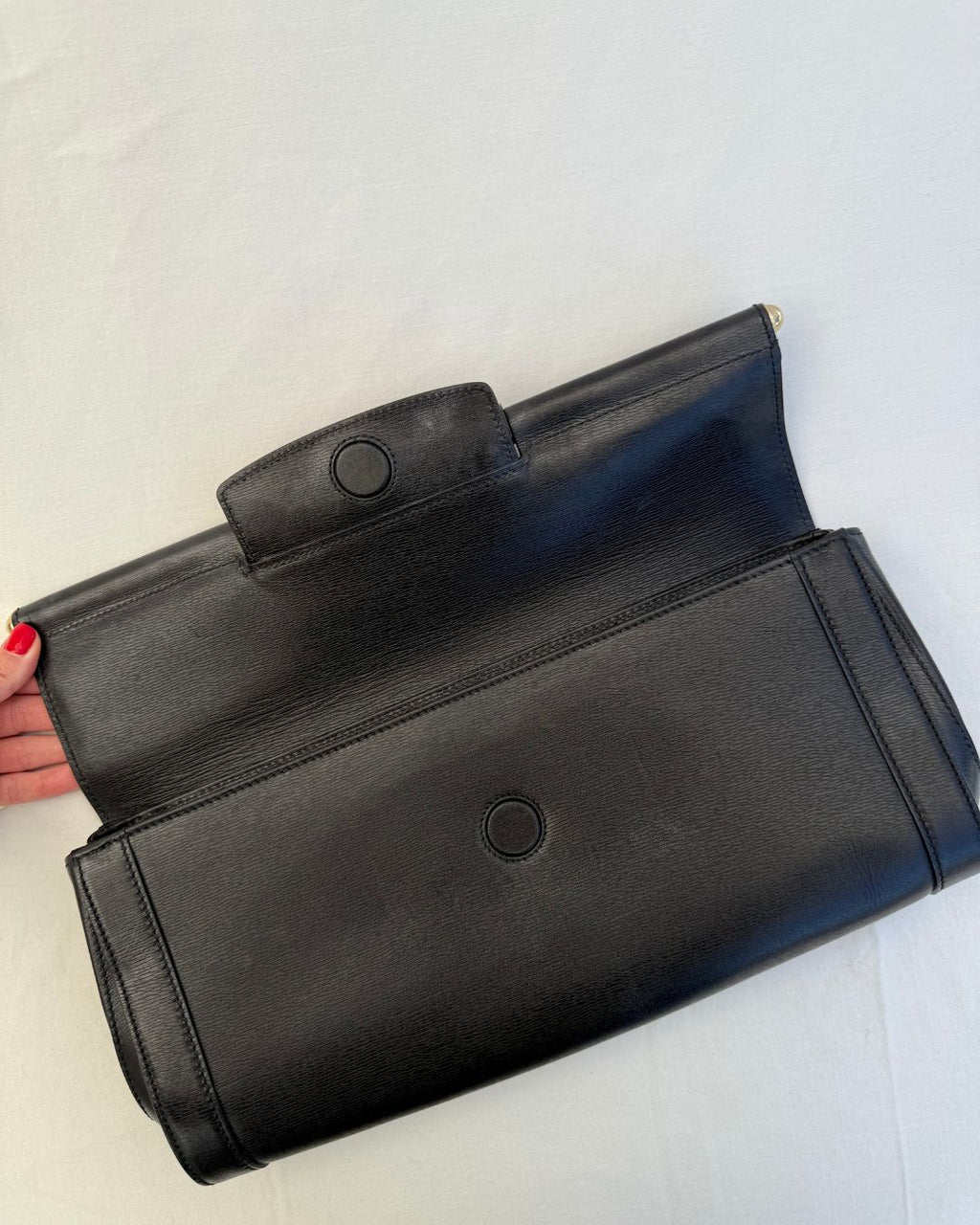 Inside view of magnetic closure for Gucci Vintage Black Leather & Bamboo Clutch on white background