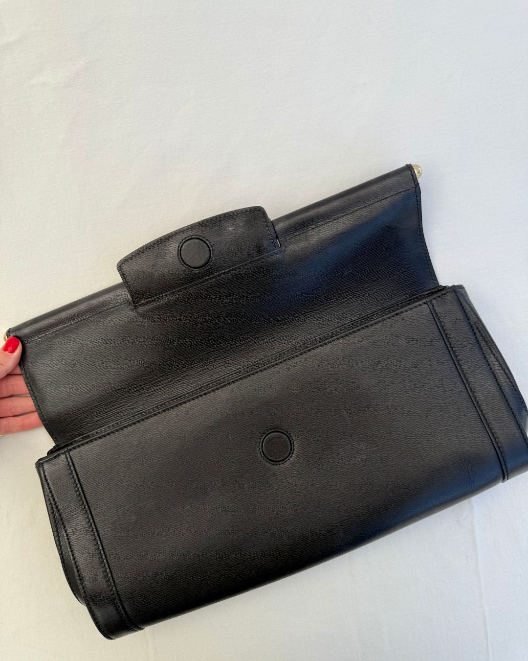 Inside view of magnetic closure for Gucci Vintage Black Leather & Bamboo Clutch on white background