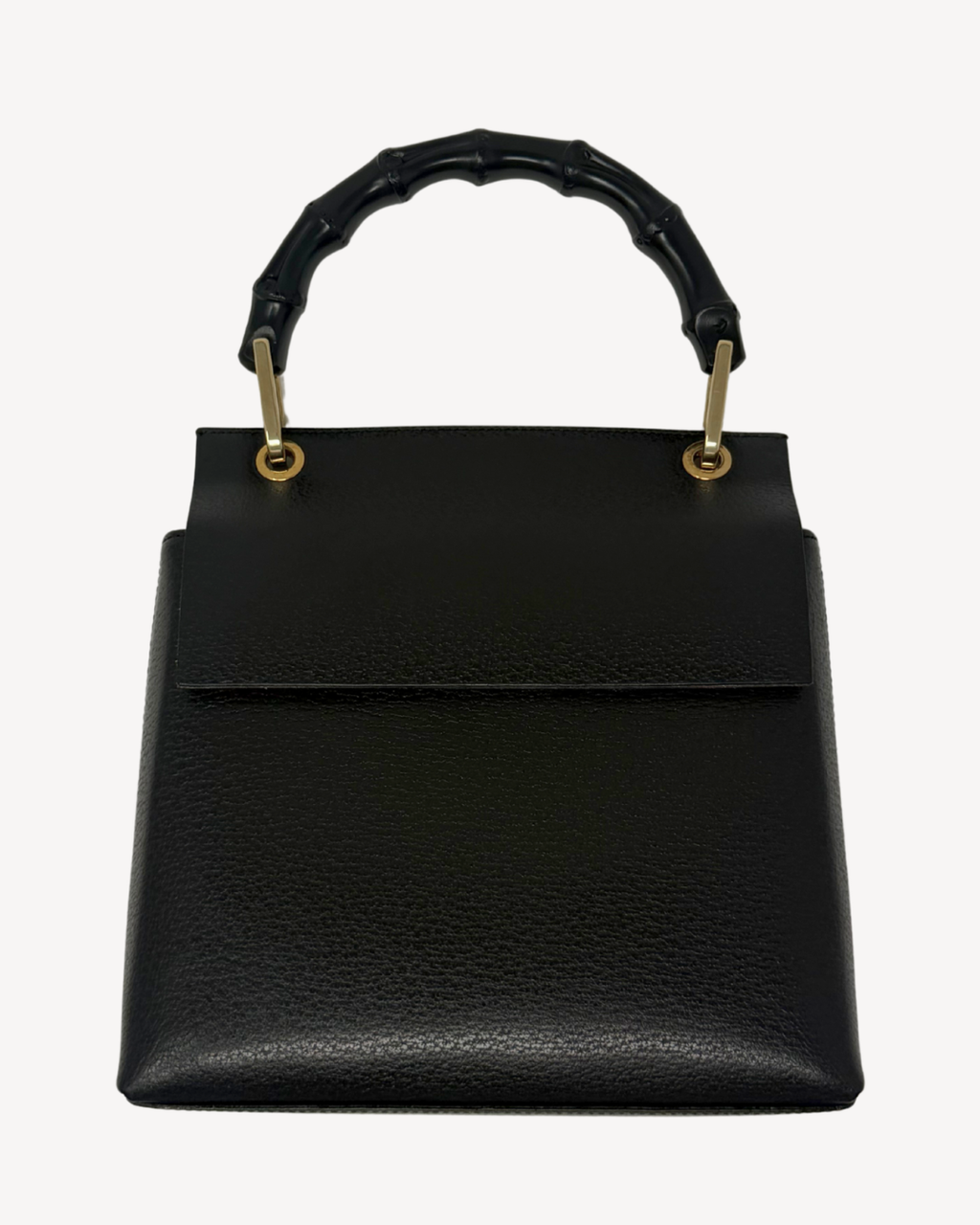 A black pebbled leather handbag with a structured rectangular shape, a top flap, and a curved bamboo-style top handle attached with gold-tone hardware, shown against a plain light background.