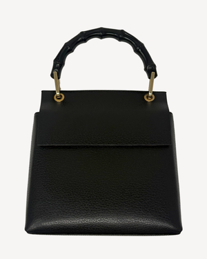 A black pebbled leather handbag with a structured rectangular shape, a top flap, and a curved bamboo-style top handle attached with gold-tone hardware, shown against a plain light background.