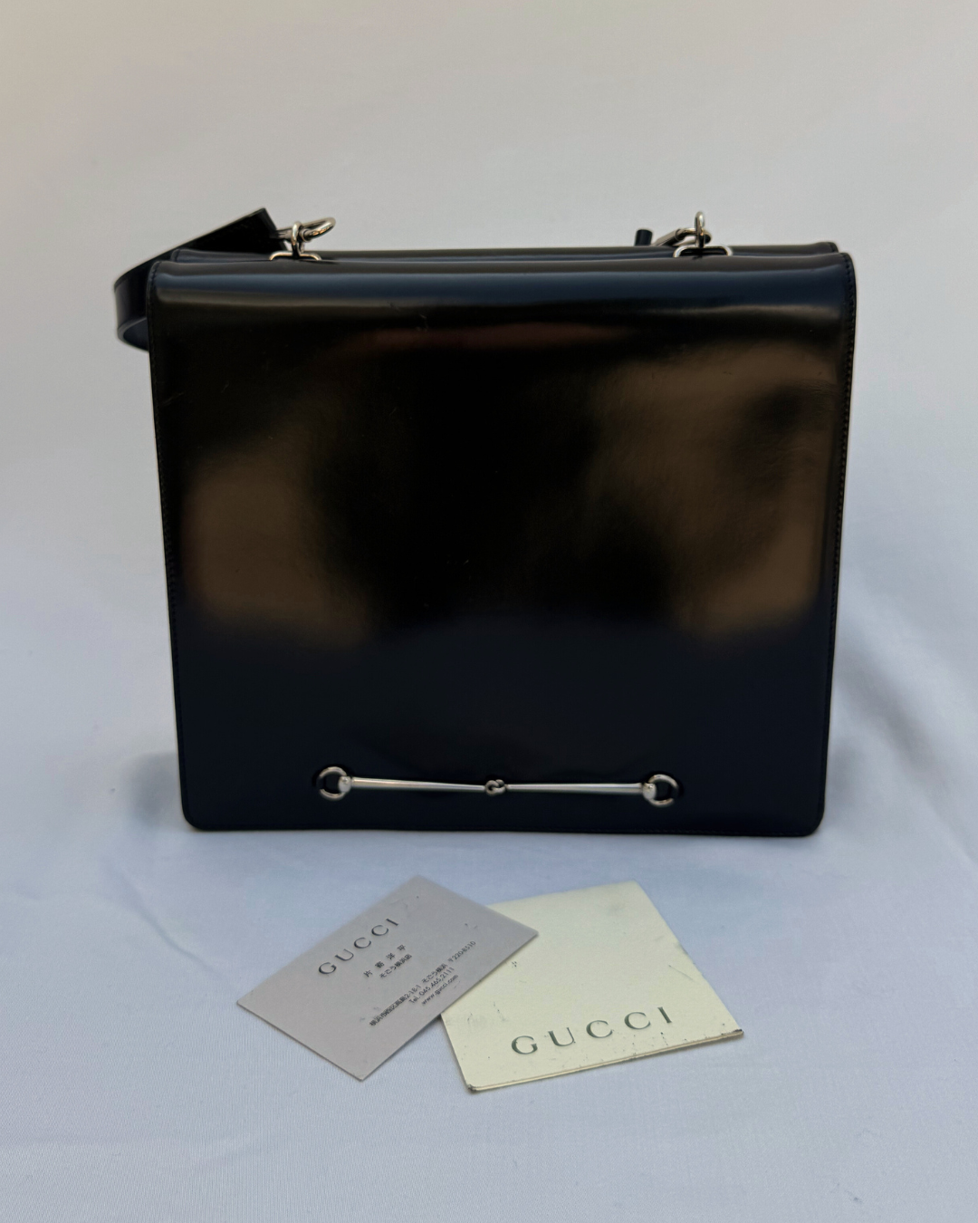 Black leather Gucci by Tom Ford vintage handbag with original authenticity cards on a white background