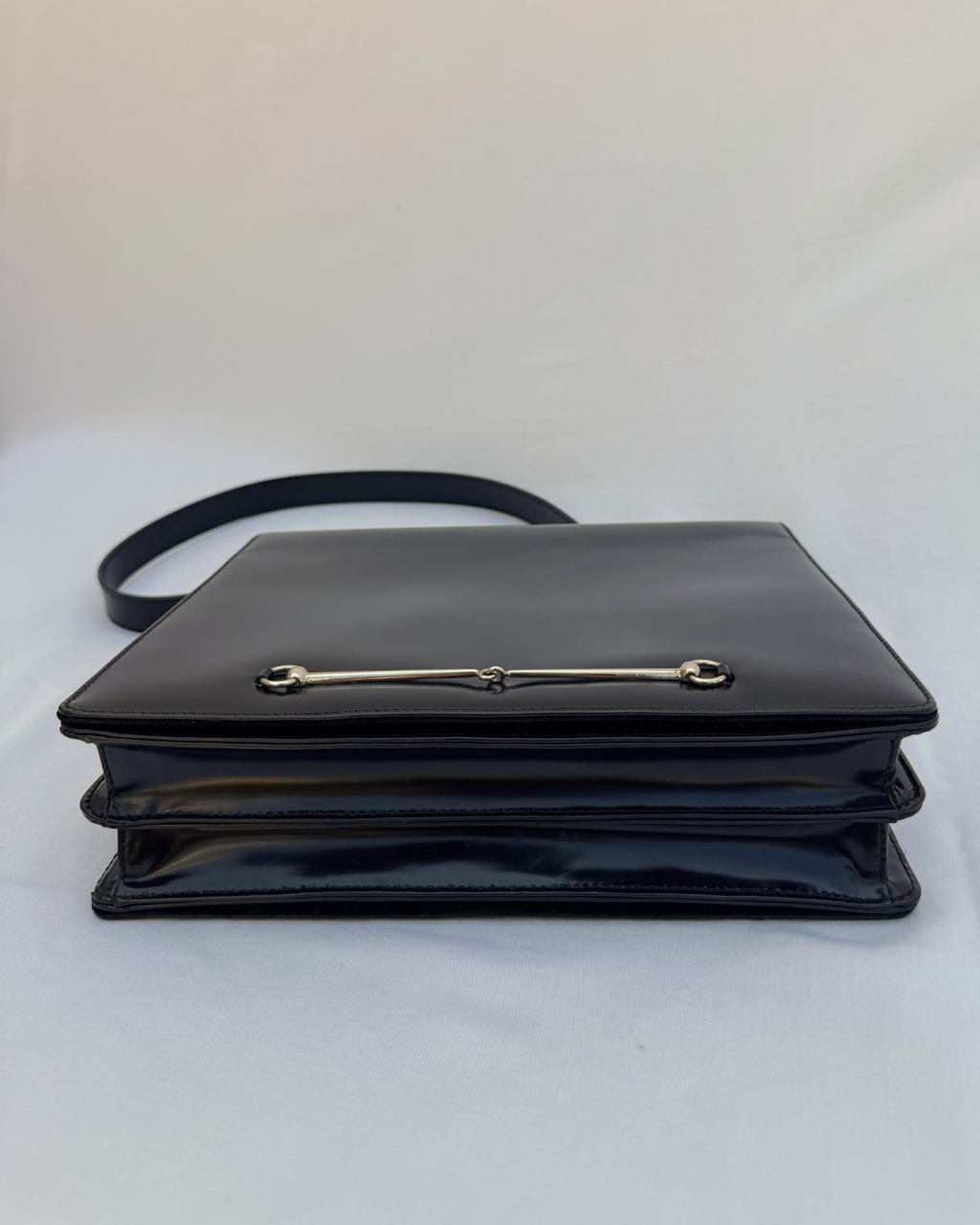 Black leather Gucci by Tom Ford vintage handbag with a silver horsebit clasp design on front on a white background bottom view