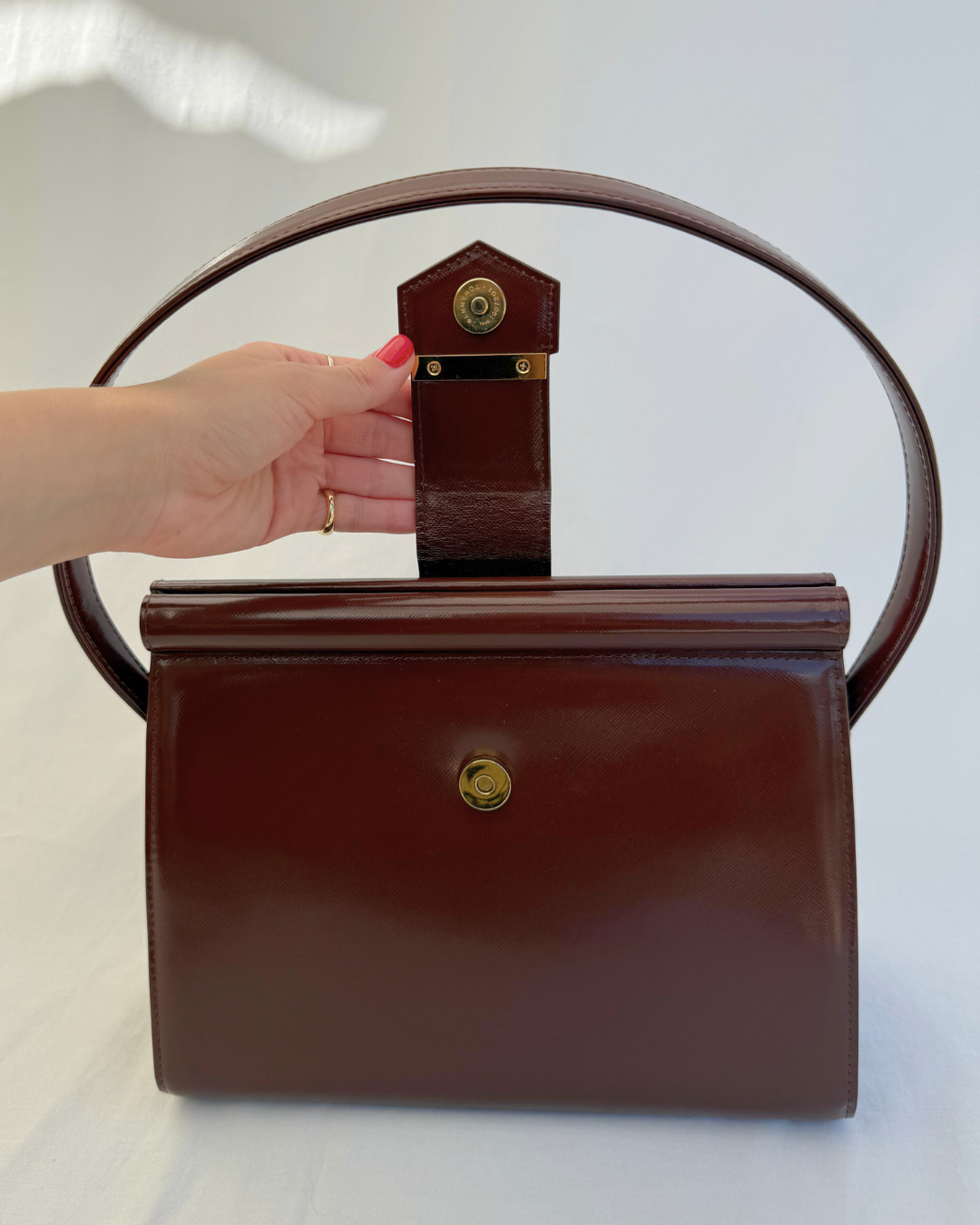 Front view showing open clasp closure for Saint Laurent Vintage Brown Leather Shoulder Bag on white background